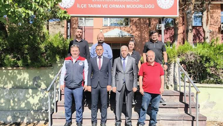 Zara Kaymakamlığı önünde, Tarım ve Orman Müdürlüğü yetkilileri ile diğer kişiler poz veriyor.