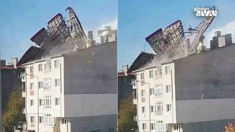 Bir apartmanın çatısı, şiddetli fırtına nedeniyle uçuyor ve etrafa parçalar savruluyor.