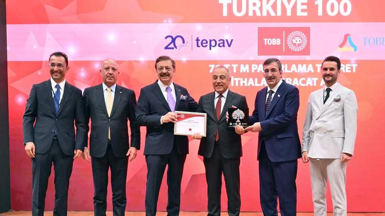 Bir grup erkek, ödül töreninde sahnede duruyor ve ödül alıyor.