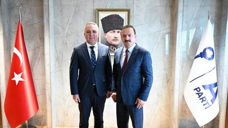 İki erkek, Türk bayrağı ve üzerinde “PARTİ” yazısı bulunan bayrakların arasında yan yana duruyor.
