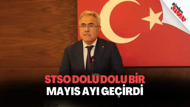 Kırmızı arka planda Türk bayrağı ile bir kişi konuşma yapıyor.