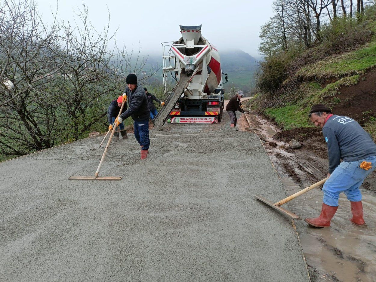 Yolda çalışan işçiler, beton dökme işlemi yapıyorlar.
