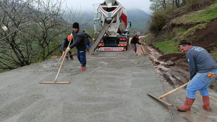 Yolda çalışan işçiler, beton dökme işlemi yapıyorlar.