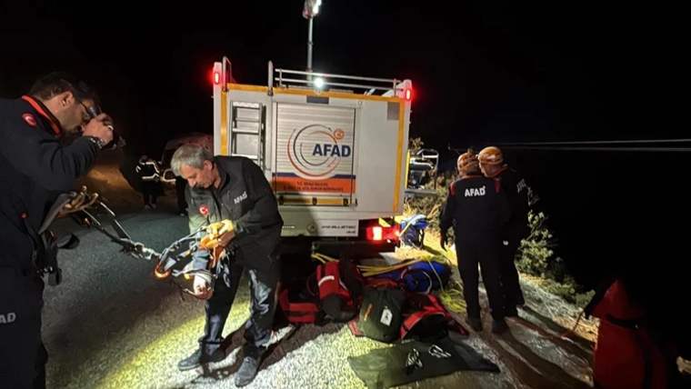 Gece yol kenarında AFAD aracı, görevli kişiler ve yere serilmiş kurtarma ekipmanları görülüyor.