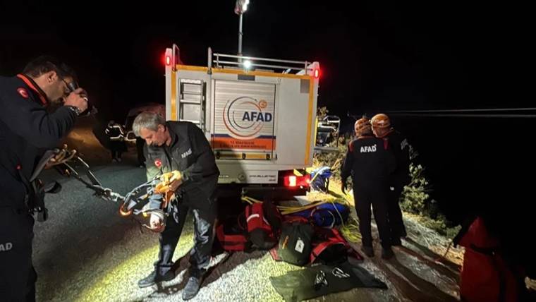 Gece yol kenarında AFAD aracı, görevli kişiler ve yere serilmiş kurtarma ekipmanları görülüyor.