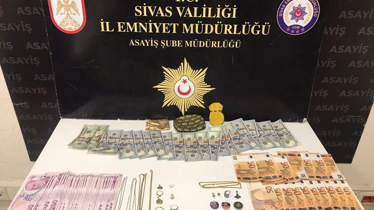 Üzerinde Türk Lirası ve Dolar bulunan banknotlar, altın ve çeşitli takılar masanın üzerinde serili.