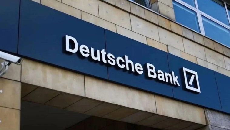 Taş kaplı bina cephesinde, mavi zemin üzerindeki Deutsche Bank tabelası ve logosu görülüyor.