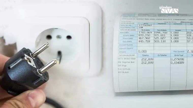 Beyaz priz yanında elde tutulan siyah fiş ve üzerinde tüketim bilgileri bulunan elektrik faturası görülüyor.