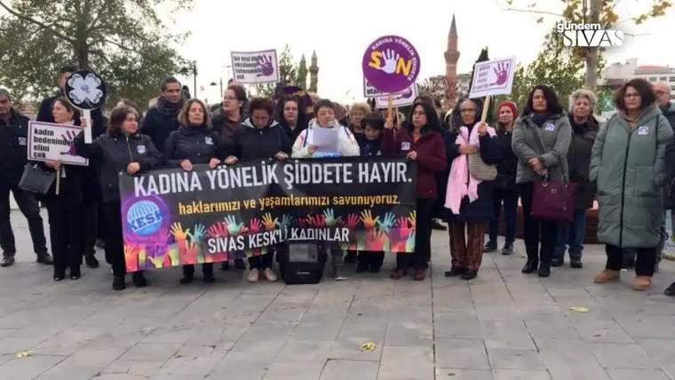 Kadına yönelik şiddete hayır yazılı pankart tutan kadınlar, kalabalık bir grup oluşturmuş.