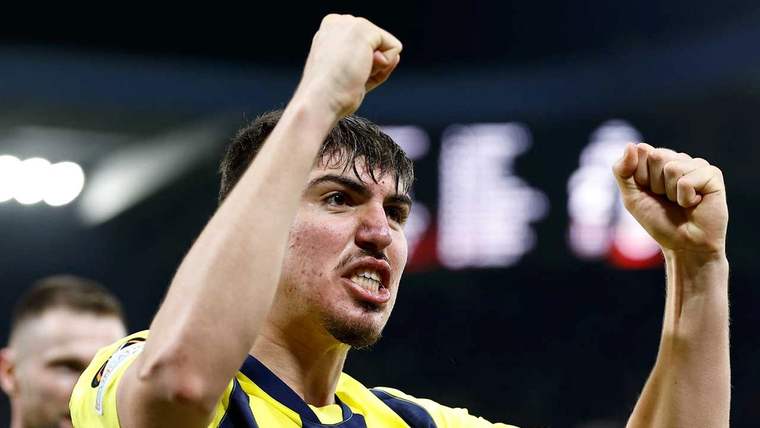 Sarı-lacivert formalı bir futbolcu, tribünleri bulanık görünen stadyumda iki yumruğunu havaya kaldırıyor.