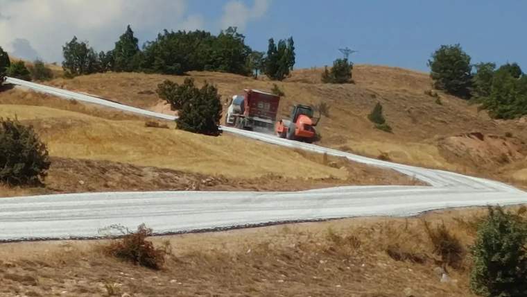 Kırkpınar Çağlayan Köy Yolu'nda yol yapım çalışması yapan bir iş makinesi, yolda ilerliyor.