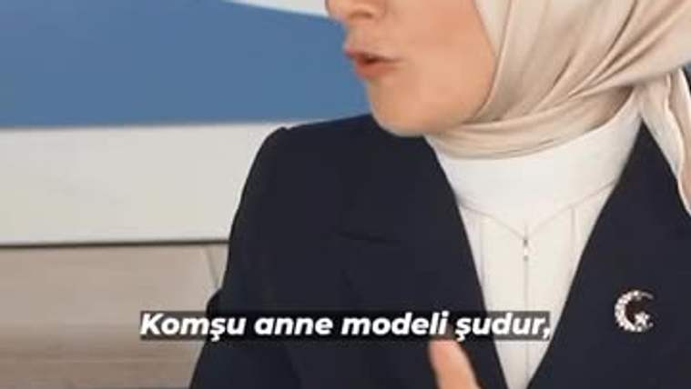 Başında başörtüsü olan bir kadın, elini hareket ettirerek konuşuyor.