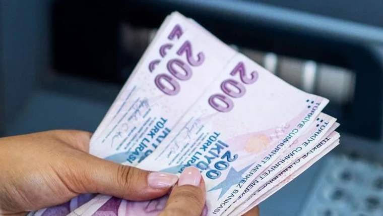 Bir kişinin elinde 200 TL banknotlardan oluşan bir deste para var.