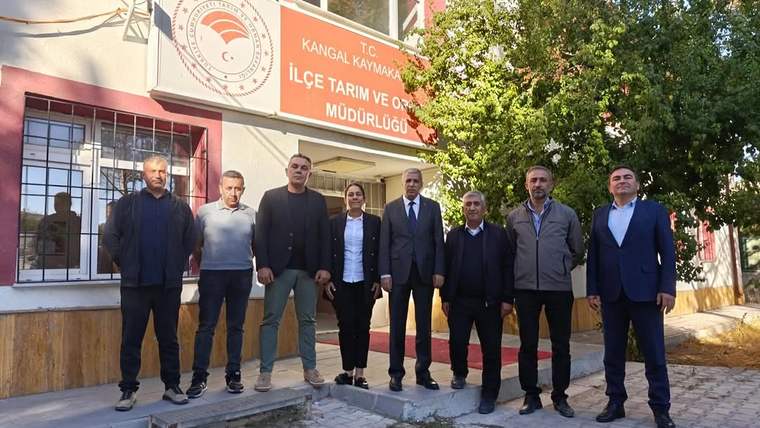 Üzerinde Kangal Kaymakamlığı ve İlçe Tarım ve Orman Müdürlüğü yazan bina önünde sekiz kişi duruyor.