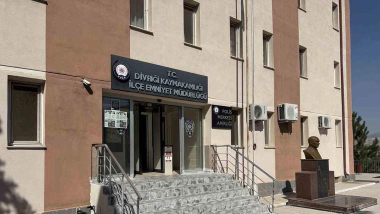 Üzerinde “Divriği Kaymakamlığı İlçe Emniyet Müdürlüğü” yazan binanın giriş merdivenleri ve önündeki büst.