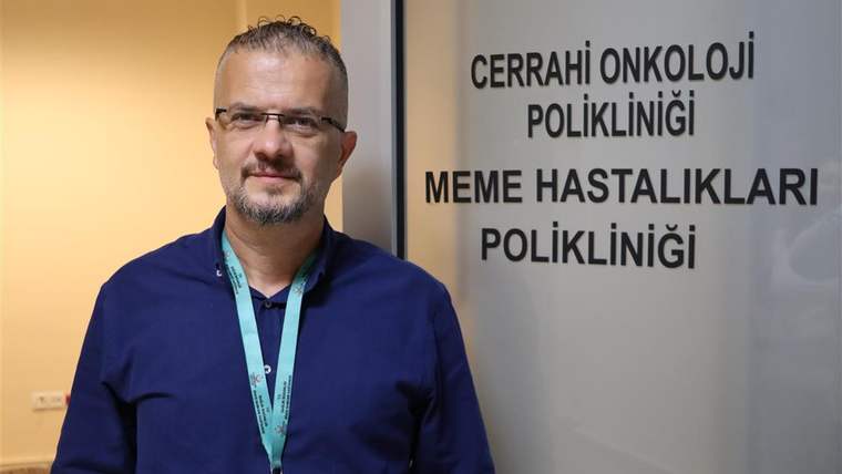 Bir kişi, “Cerrahi Onkoloji Polikliniği” ve “Meme Hastalıkları Polikliniği” yazılı kapı önünde duruyor.