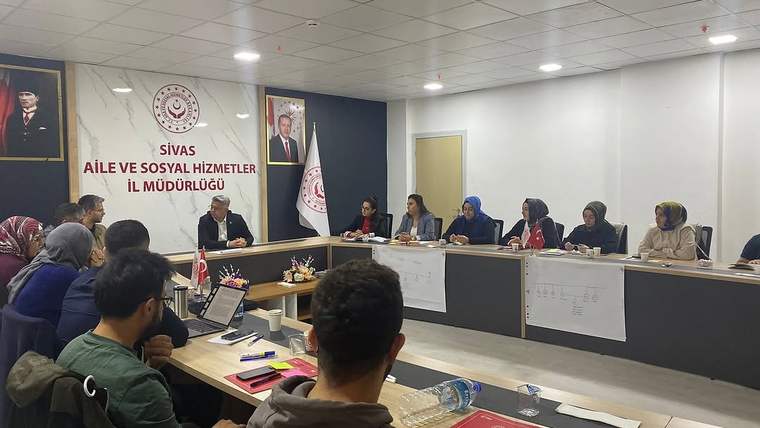 Bir grup insan, Sivas Aile ve Sosyal Hizmetler İl Müdürlüğü'nde eğitim toplantısında bir araya gelmiş.