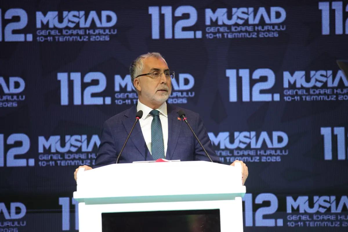 Kürsüde konuşan bir kişi, arka planda MÜSİAD logosu ve etkinlik bilgileri yer alıyor.