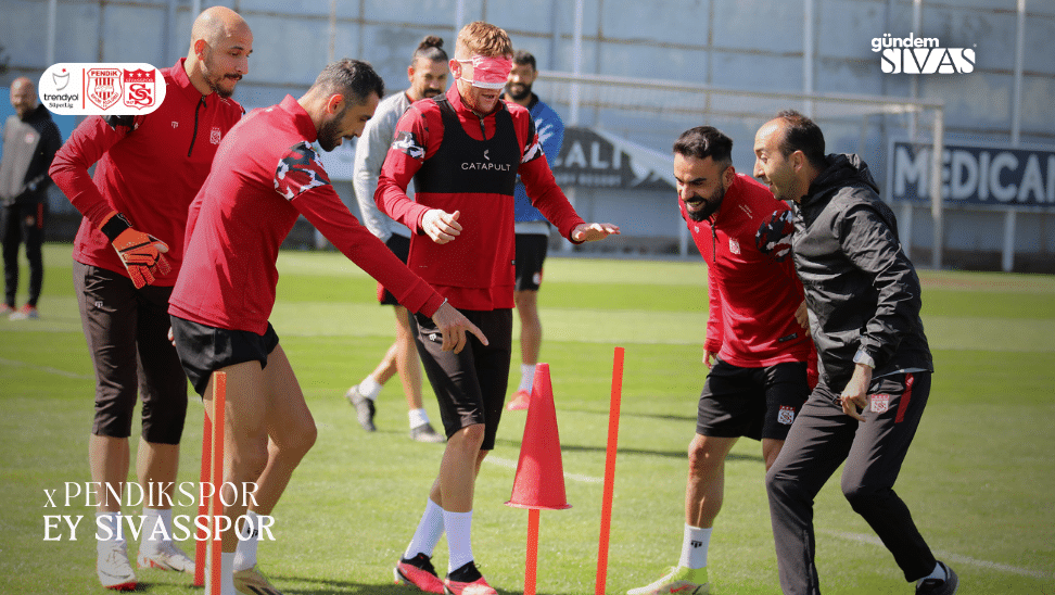 Gözleri kapalı bir futbolcu, antrenman sırasında diğer oyuncularla birlikte koni etrafında koşuyor.