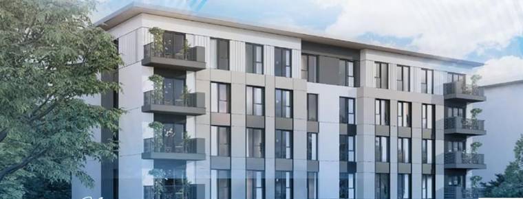Balkonları ve geniş camları görülen, ağaçlarla çevrili modern çok katlı apartman binası