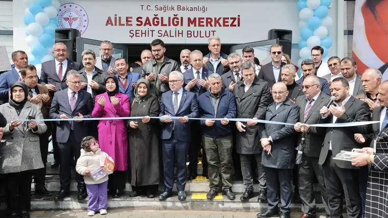 Şehit Salih Bulut Aile Sağlığı Merkezi'nin açılışında kurdele kesen kalabalık bir grup.