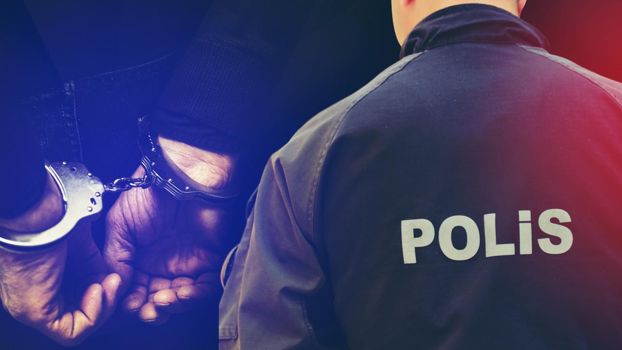 Sırtında POLİS yazısı bulunan görevlinin önünde, elleri kelepçeli bir kişinin yakın planı görülüyor.