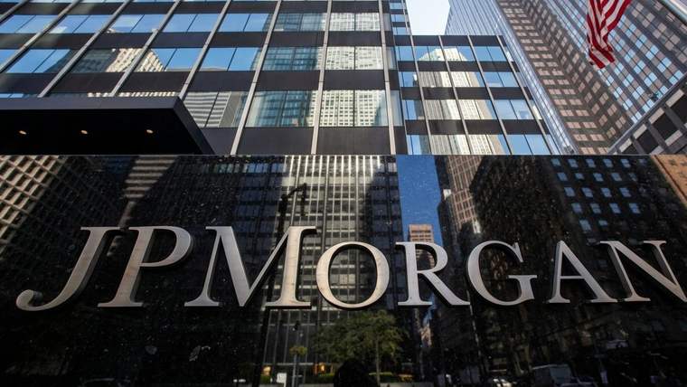 JPMorgan yazılı binanın önünde yüksek katlı cam yapılar ve bir ABD bayrağı görülüyor.