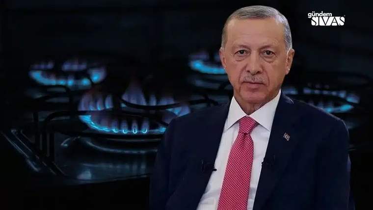 Arka planda yanan doğalgaz ocaklarıyla birlikte bir kişi, kameraya bakıyor.