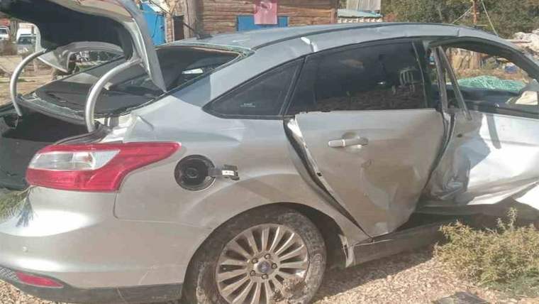 Yan tarafı ve kapısı hasar görmüş gümüş renkli otomobil, yol kenarında park halinde duruyor.