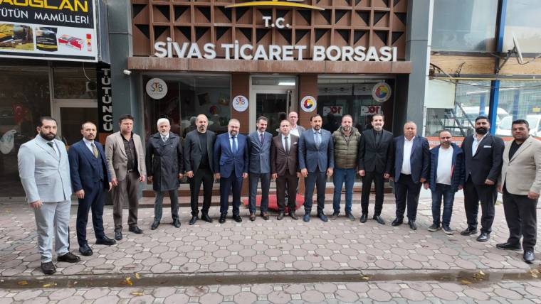 Sivas Ticaret Borsası tabelası önünde, kaldırımda yan yana duran bir grup insan görülüyor.