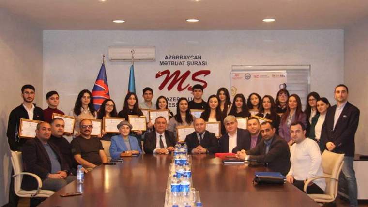 Azerbaycan'da fotoğraf gazeteciliği eğitim programını tamamlayan katılımcılar, sertifikalarıyla birlikte bir arada poz veriyor.