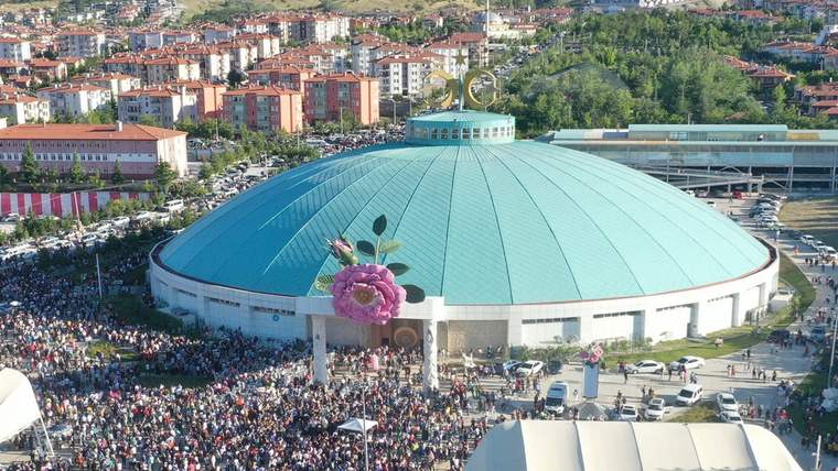 Isparta Tarım Fuarı'nın yapıldığı büyük bir kapalı alan, önünde kalabalık bir ziyaretçi grubu var.