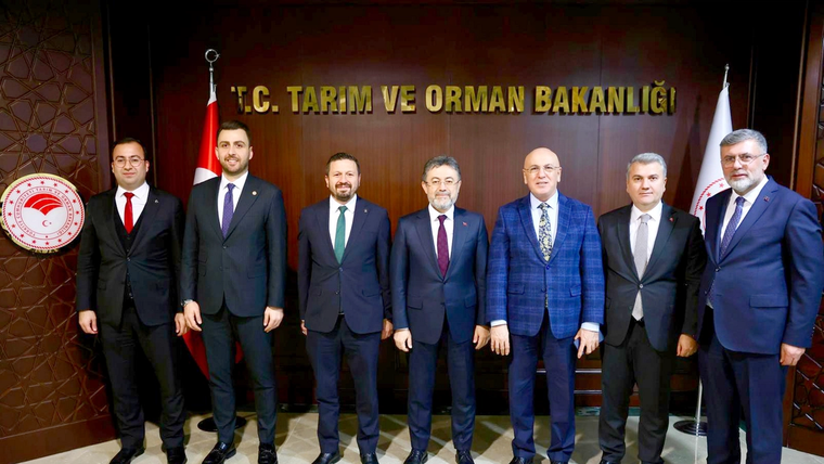 T.C. Tarım ve Orman Bakanlığı yazılı panonun önünde takım elbiseli yedi erkek yan yana duruyor.