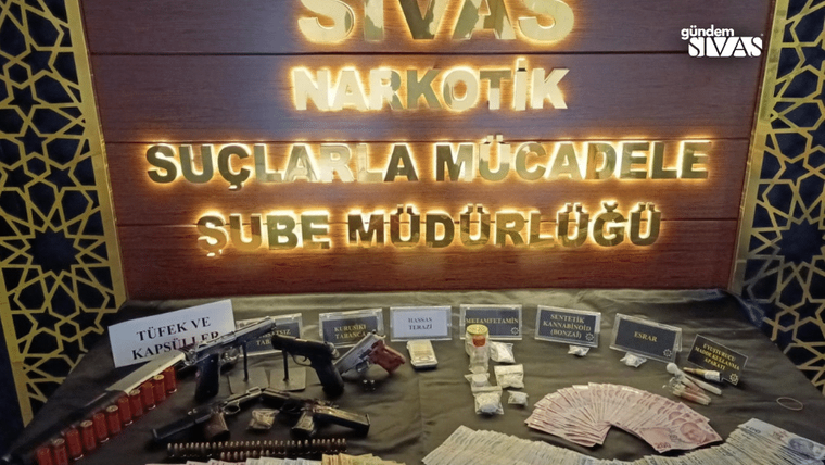 Sivas Narkotik Suçlarla Mücadele Şube Müdürlüğü tabelası önünde uyuşturucu maddeler ve silahlar sergileniyor.