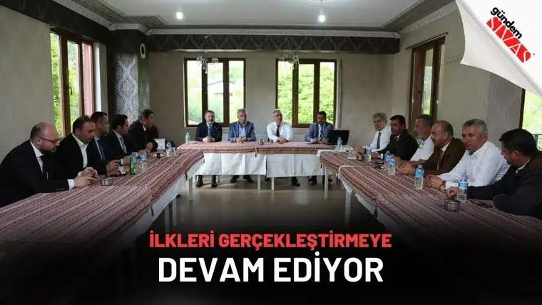 Bir toplantı odasında, uzun bir masa etrafında oturan on dört kişi, Zeki Özdemir'in başında olduğu bir toplantıya katılıyor.