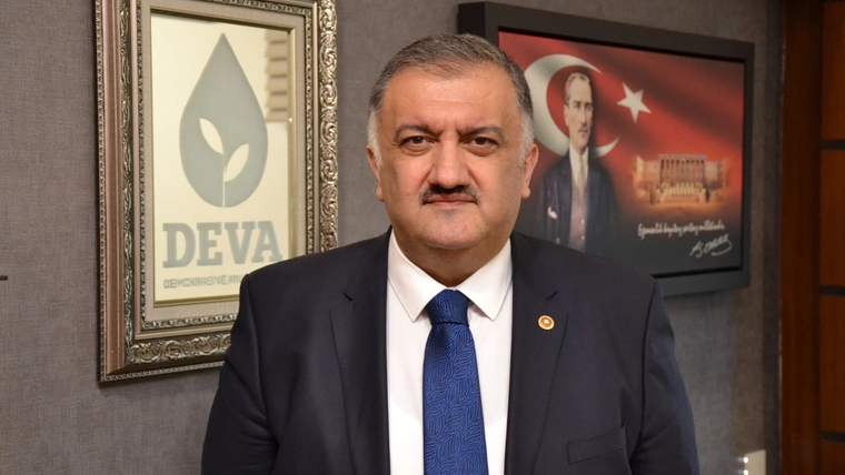 DEVA Partisi logosunun bulunduğu bir çerçeve ve arka planda Atatürk'ün portresi ile bir kişi, resmi bir kıyafet giymekte.
