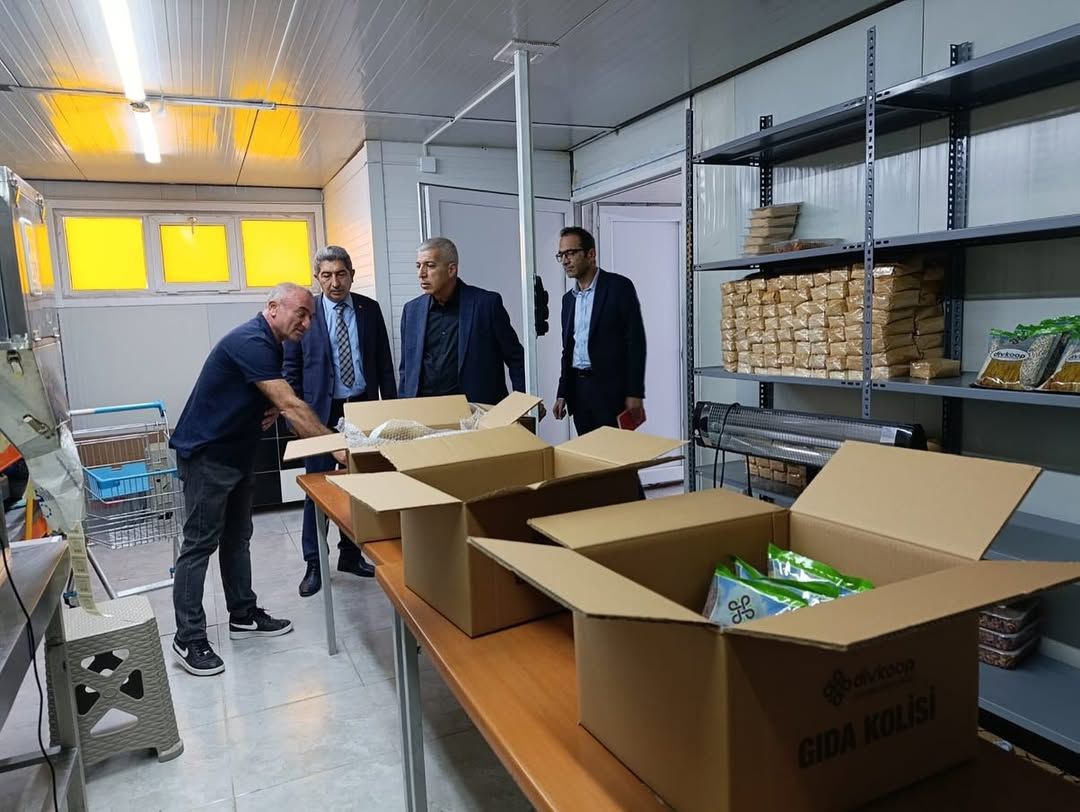 Dört kişinin bulunduğu işletmede açık karton kutular masalarda, raflarda paketlenmiş ürünler görülüyor.