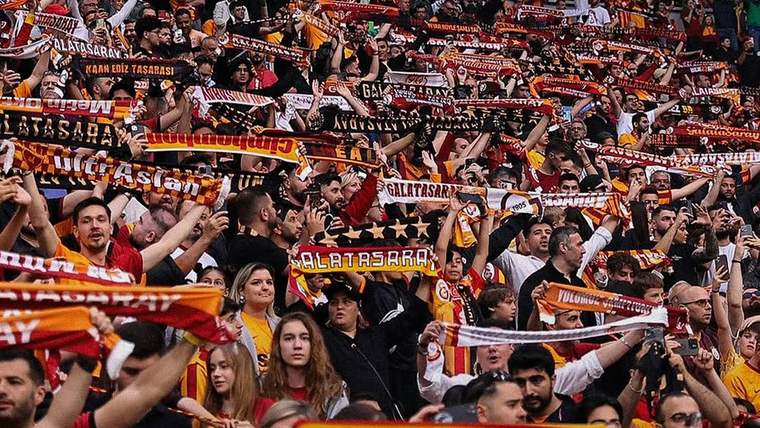 Stadyumda, Galatasaray taraftarları takım atkılarıyla coşkulu bir şekilde destek veriyor.