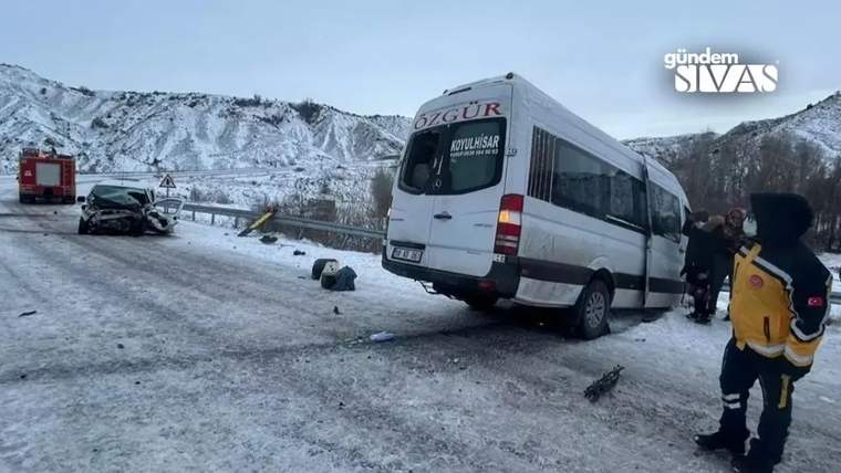 Karlı yolda devrilmiş bir minibüs, hasarlı otomobil, itfaiye aracı ve çevrede duran kişiler görülüyor.