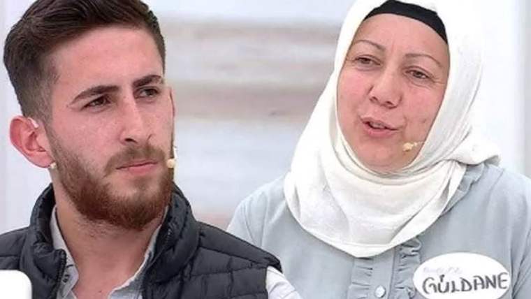 Bir erkek ve bir kadın, televizyon programında konuşuyor. Kadın başında beyaz bir örtü var, erkek ise sakallı ve ceket giymekte.