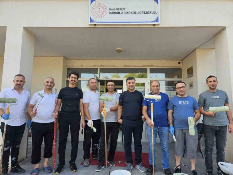 Durdulu İlkokulu ve Ortaokulu girişinde, ellerinde boya araçları bulunan bir grup erkek yan yana duruyor.