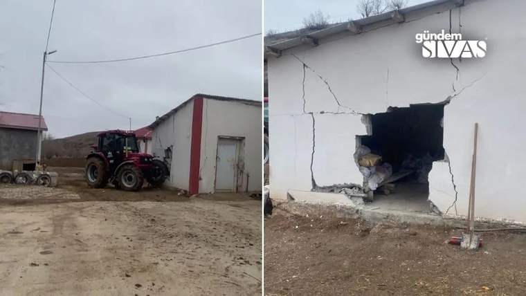 Kırmızı bir traktör, bir binanın duvarına çarpmış ve duvarda büyük bir delik oluşmuş.