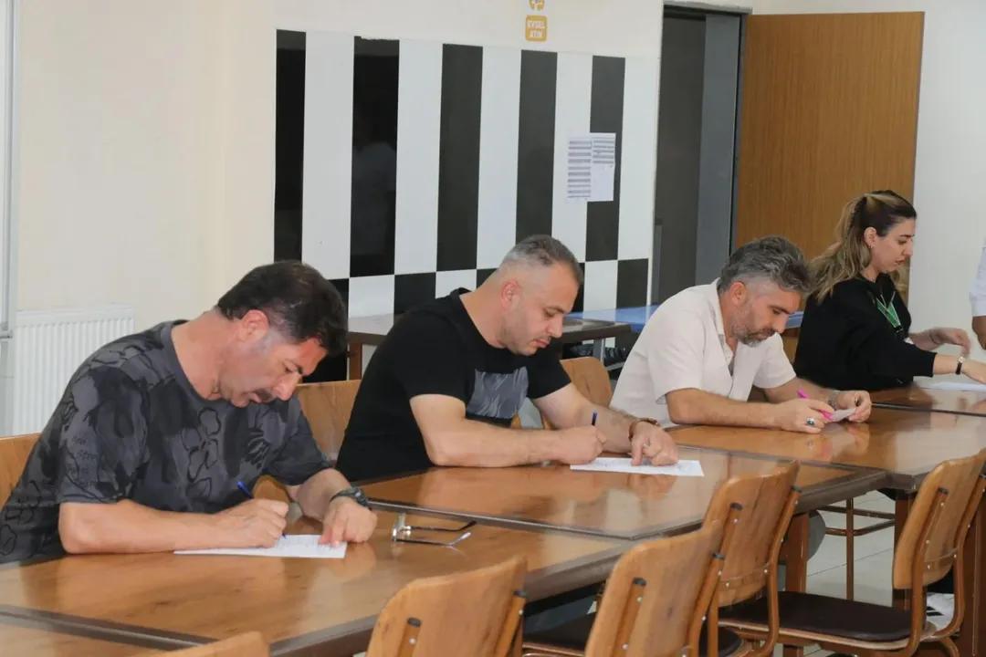 Dört kişi, bir masanın etrafında oturarak anket dolduruyor.