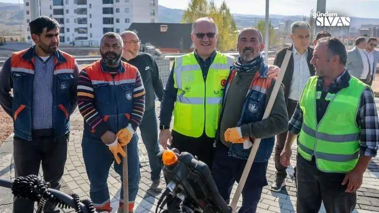 Başkan Bilgin, işçilerle birlikte inşaat alanında poz veriyor.