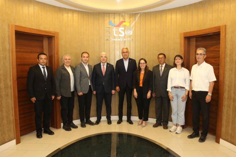 STSO binası önünde, STSO Başkanı ve sekiz kişi birlikte poz veriyor.