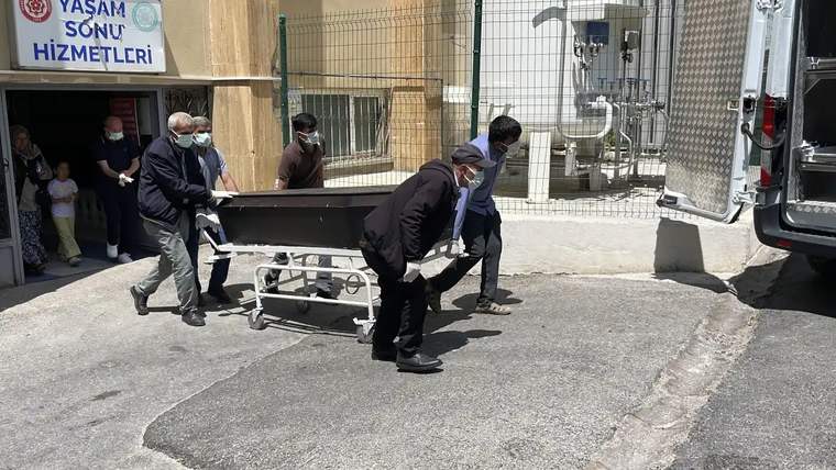 Bir grup insan, morgdan bir tabutu taşıyor.
