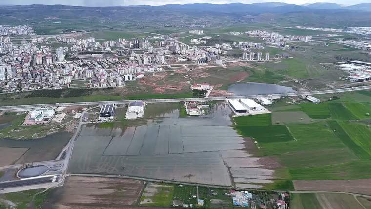 Su birikintileriyle kaplı tarım arazileri ve çevresindeki yerleşim alanları görünmekte.