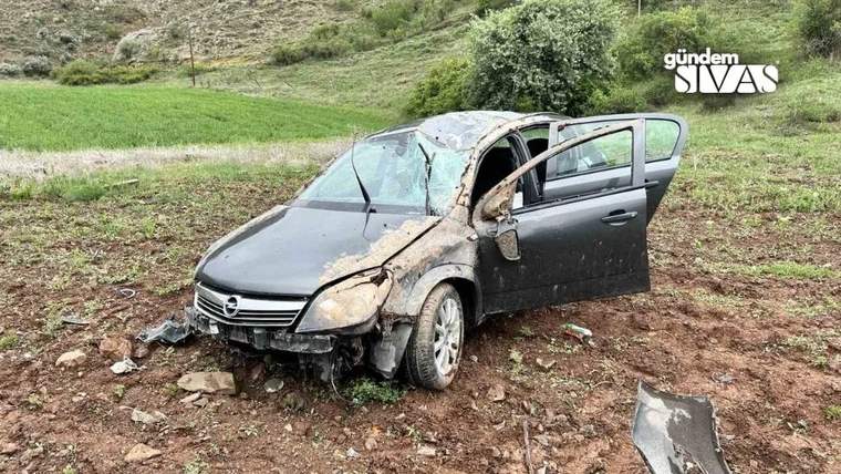 Kaza yapmış bir otomobil, yan yatmış ve etrafında toprak ve çamur var.