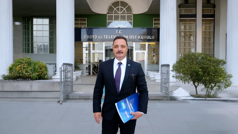T.C. Radyo ve Televizyon Üst Kurulu binası önünde, elinde dosya tutan bir kişi duruyor.