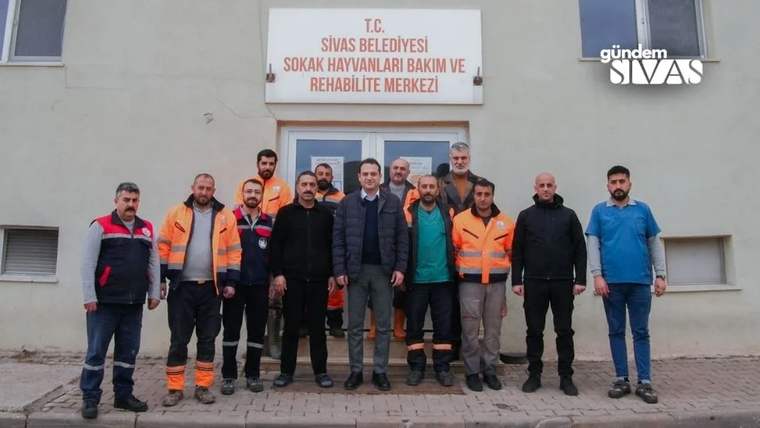 Sivas Belediyesi Sokak Hayvanları Bakım ve Rehabilitasyon Merkezi önünde bir grup kişi yan yana duruyor.